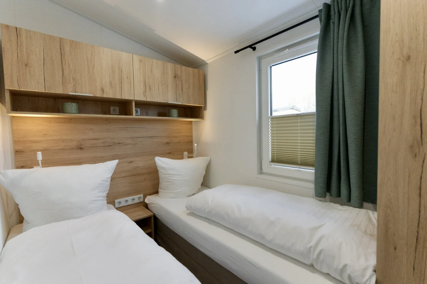 Schlafzimmer mit 2 Einzelbetten und Plissee am Fenster im Ferienhaus Scharbeutz "KleineDuene".